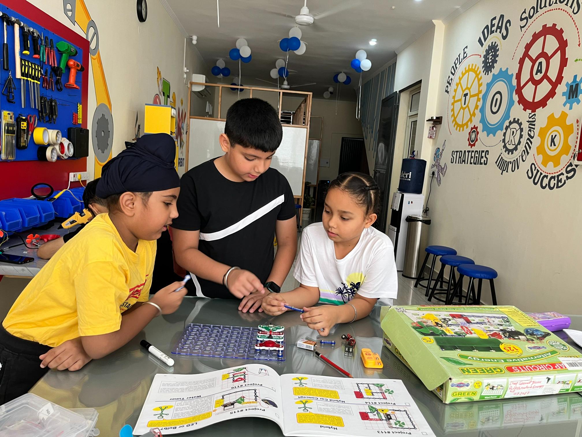 Children working with robotics kits at camp